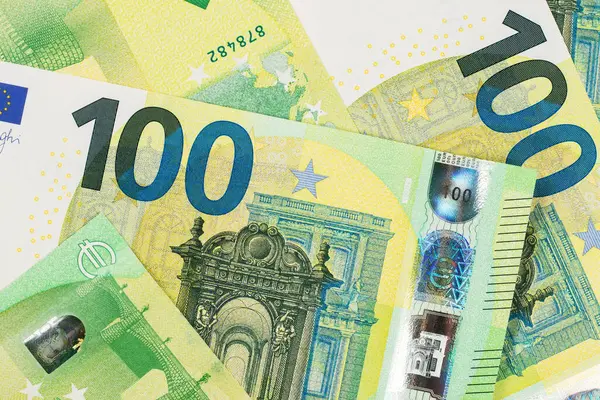 Euro currency, offers 100 euro bank note on table.