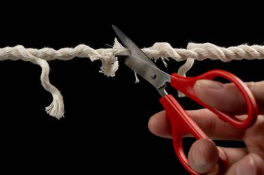 Siyah zemin üzerinde makas ile aşınmış ip kırılmaya hazır