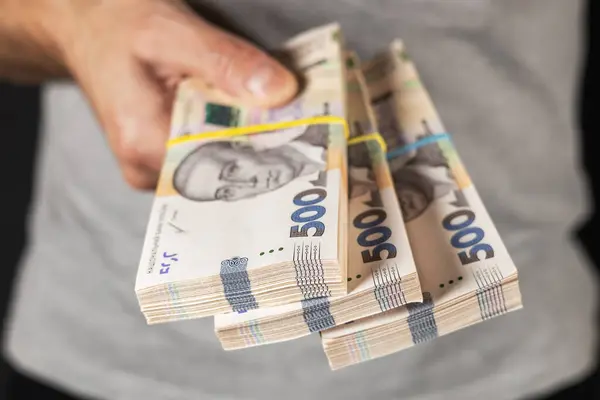Adam elinde bir yığın Hryvnia tutuyor. Ukrayna parası. İş konsepti. 500 Hryvnia banknotu.