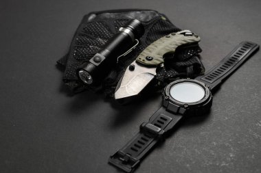 Everyday carry EDC items for men in black color - flashlight, watch and knife. Survival set. Minimal concept.