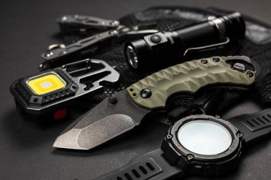 Her gün taktik bıçak, el feneri, saat ve gümüş çoklu alet gibi siyah renkli adamlar için EDC eşyaları taşır. Hayatta kalma seti. Asgari konsept.