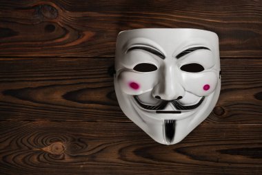 Dinyeper. Ukrayna 30 Ocak 2024: Tahta arka planda Vendetta maskesi. Bu maske, Anonymous adlı çevrimiçi hacktivist grubun iyi bilinen bir sembolü..