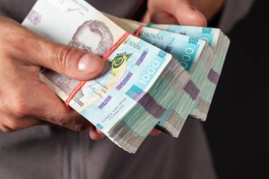 Ukrayna parası elinde tutan adam 1000 Hryvnia banknotu. Yakın çekim.
