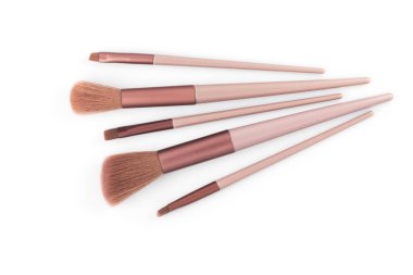 Beyaz arkaplanda izole edilmiş pembe makyaj fırçaları.