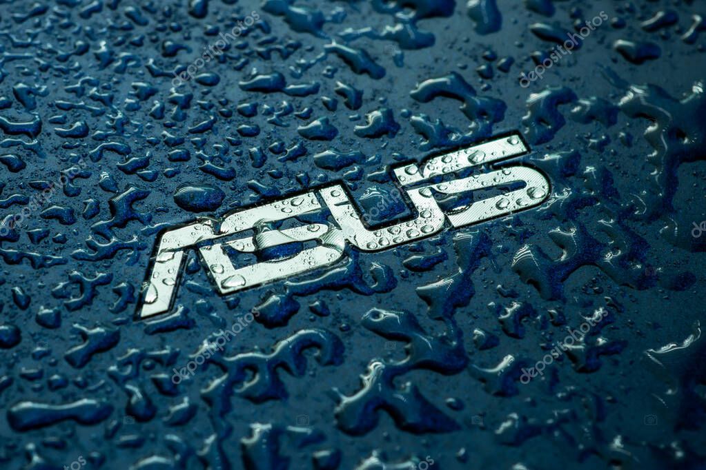 UKRAINE, DNEPR - OCT 02, 2023: ASUS company logo on laptop with water drops.