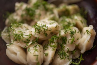 Kızarmış hamur tatlısı, et ile doldurulmuş kase içine dereotu serpiştirilmiş..