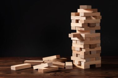 Koyu arkaplandaki tahta bloklardan yapılmış kule, metin için boşluk.