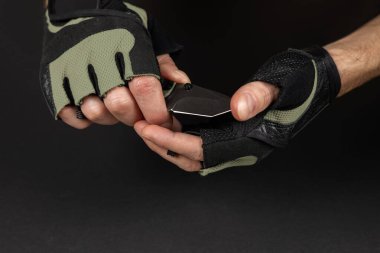 Katlanan bıçakla taktik eldiven giyen adam..