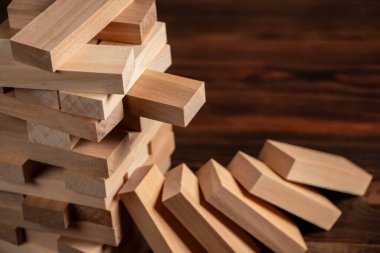 Koyu arkaplanda tahta bloklardan yapılmış Jenga kulesi, metin için boşluk.