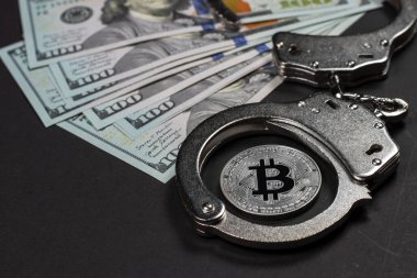 Symbolic coins of bitcoin and stack of bitcoin coins and metall handcuffs on banknotes of one hundred dollars. Exchange bitcoin for a cash dollar, but be a law-abiding citizen. clipart