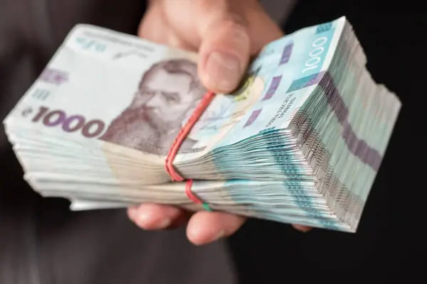 Ukrayna parası elinde tutan adam 1000 Hryvnia banknotu. Yakın çekim.