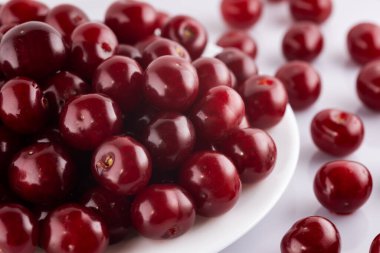 Olgun kirazlar beyaz arka planda izole edilmiş.