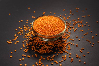 Cam kasede kırmızı mercimek. Kuru turuncu mercimek tanecikleri, dal yığını, çiğ daal, dhal, mazoor, Lens Culinaris veya Lens esculenta koyu arka planda.