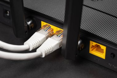 Karanlıkta bir ethernet kablosunu kablosuz yönlendiriciye bağla. Ethernet, rj45 ve elektrik kabloları yönlendiriciye bağlı. Ağ konsepti