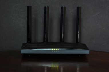 Odadaki siyah ahşap masadaki Wi-Fi yönlendirici...
