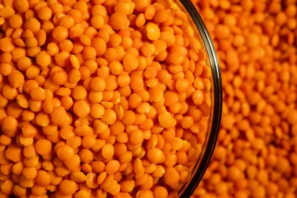 stock image Red lentils in bowl on a lentils background.