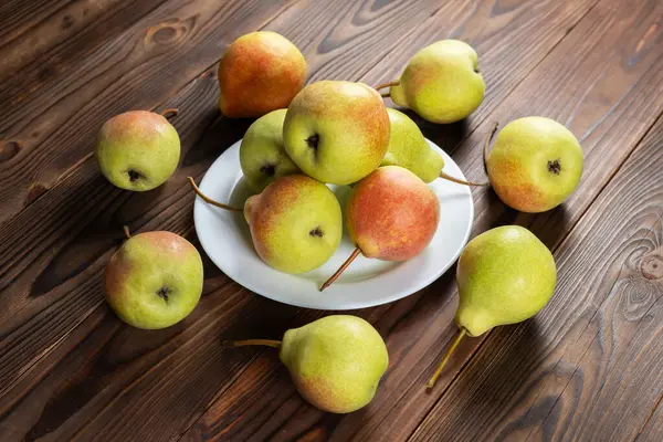 Tabakta taze armut meyvesi, ahşap masa, sağlıklı meyve.