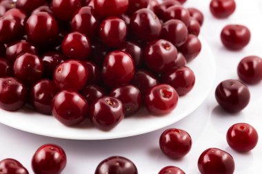 Olgun kirazlar beyaz arka planda izole edilmiş.