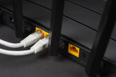 Karanlıkta bir ethernet kablosunu kablosuz yönlendiriciye bağla. Ethernet, rj45 ve elektrik kabloları yönlendiriciye bağlı. Ağ konsepti