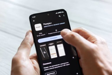 DNIPRO, UKRAINE - 16 Temmuz 2024: Erkek eller Rezerv ile akıllı telefon ve akıllı telefon için Ukraynalı uygulamayı tutuyor.