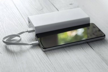 Güç bankasını şarj ediyorum. Şarj cep telefonu veya akıllı telefon pili için beyaz usb kablosu olan taşınabilir güç bankası.