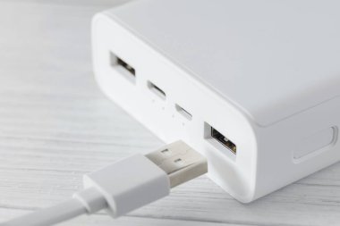 Mobil aygıtları beyaz masadaki kabloyla şarj etmek için Powerbank.