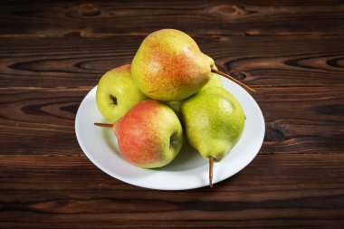 Tahta masadaki tabakta taze armut meyvesi. Sağlıklı meyve.
