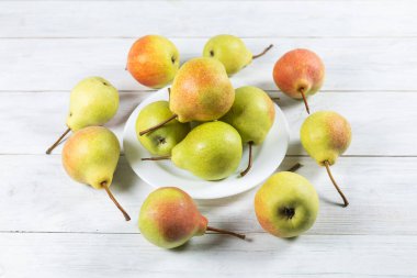 Beyaz masada bir tabakta taze armut meyvesi. Sağlıklı meyve.