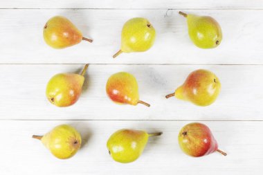 Beyaz ahşap arka planda armutlar.