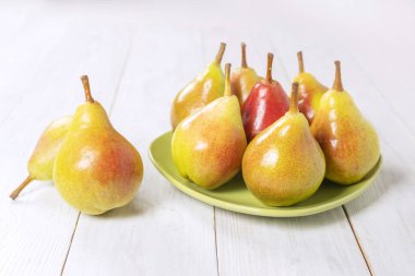 Olgun armutlar yeşil tabakta.