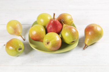 Olgun armutlar yeşil tabakta.