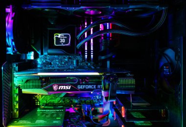 Dinyeper. Ukrayna - Ağustos 02. 2024: RGB parlayan LED ışıkları, CPU su soğutma sistemi ve karanlık odada NVidia GeForce RTX grafik kartı olan modern oyun bilgisayarı..
