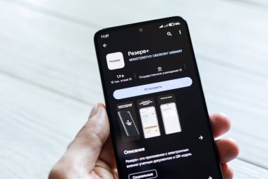 DNIPRO, UKRAINE - 16 Temmuz 2024: Erkek eli Rezerv ile birlikte akıllı telefonu tutuyor artı - akıllı telefon için Ukraynalı uygulama ve askere alınma durumuyla ilgili kişisel bilgiler