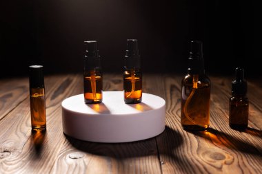 Kozmetik için çeşitli kehribar cam şişeleri, doğal ilaçlar, temel yağlar ya da ahşap arka plandaki diğer sıvılar.