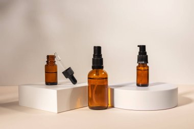 Geometrik kaide podyumunda kehribar kozmetik şişesi, bitkilerin doğal gölgelerini içeren ürün ambalajı, peptitli yaşlanma önleyici serum, kozmetik modelleme, biyofilik konsept..