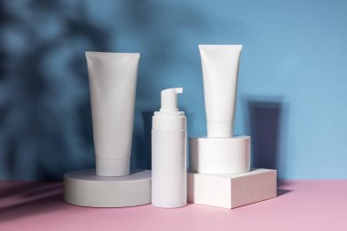 Geometrik kaide podyumunda kozmetik tüp ve şişe, bitkilerin doğal gölgeleriyle ürün ambalajı, peptitli yaşlanma önleyici serum, kozmetik modelleme, biyofilik konsept.