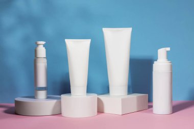 Geometrik kaide podyumunda kozmetik tüp ve şişe, bitkilerin doğal gölgeleriyle ürün ambalajı, peptitli yaşlanma önleyici serum, kozmetik modelleme, biyofilik konsept.