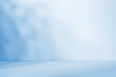 Asgari soyut hafif mavi arkaplan, duvardaki ağaç dallarından gelen ışık ve karmaşık gölgelerle ürün sunumu için.