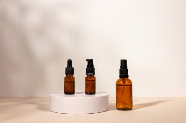 Beyaz podyumda pipetli Amber kozmetik şişesi, ürün ambalajı, peptitli yaşlanma önleyici serum, kozmetik modelleme, spa konsepti.