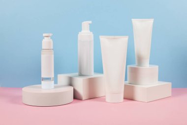 Podyumda etiketsiz beyaz plastik tüpler. Kozmetik ürünleri reklamı sahnesi.