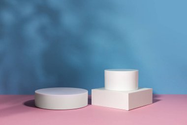 Gölgeli ve ışıklı ürün sunumu için mavi arkaplan. Boş podyumlar. Model.