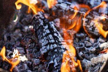 Yanan odun Yakacak odun yanıyor. Ateş dilleri. turuncu alev. Şenlik. Odun ateşinde pişirme. Yakacak odun barbekü yapmak için yanıyor.