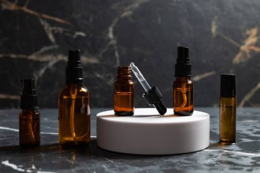 Koyu arkaplanda yüz estetiği olan kehribar şişeleri..