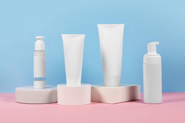 Podyumda etiketsiz beyaz plastik tüpler. Kozmetik ürünleri reklamı sahnesi.