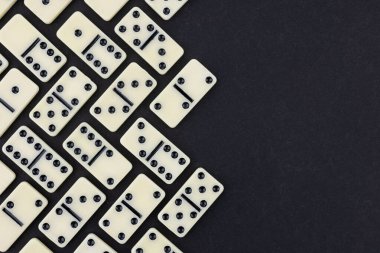 Siyah arka planda klasik domino taşları, düz yatış. Metin için boşluk.