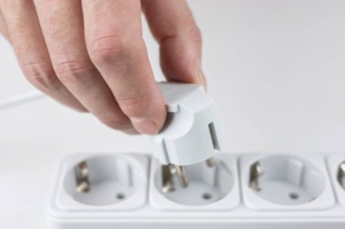 Kadının elinin prizine elektrik prizi yerleştirirken yakın plan görüntüsü. Elektrik aygıtlarına bağlanılıyor.