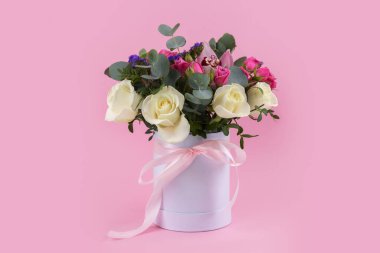 Güzel bir buket gül ve vazo çiçekleri içinde pembe bir arkaplanda orkide..