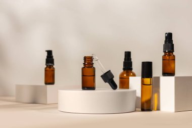 Beyaz podyumda pipetli Amber kozmetik şişesi, ürün ambalajı, peptitli yaşlanma önleyici serum, kozmetik modelleme, spa konsepti.