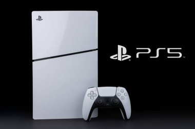 Dnipro Ukrayna - 29 Aralık 2024: New Sony PlayStation 5 Slim Beyaz Oyun Denetleyicisi Dualsense ile dikey olarak duruyor