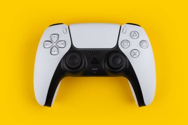 Dnipro Ukrayna - 29 Aralık 2024: Playstation 5 oyun çift duyu kontrolörü sarı arkaplanda izole edildi. Sony ps5 oyun alanı.